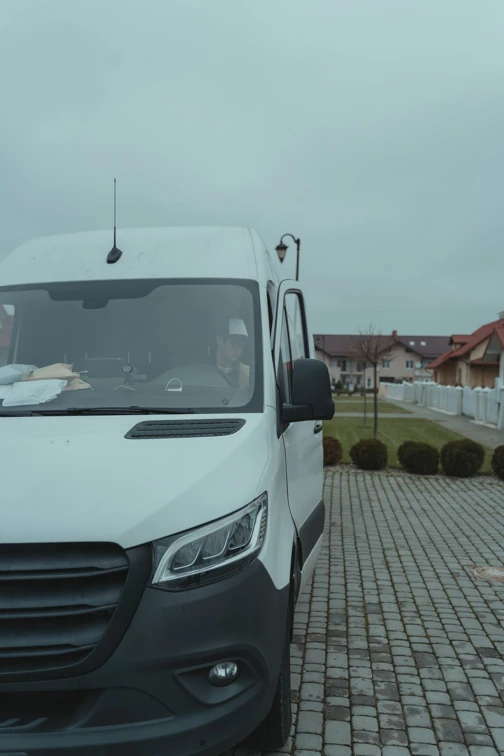 A courier approaching a delivery van with parcels ready for delivery.