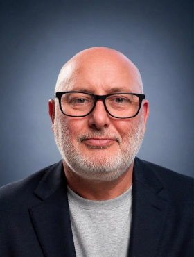 Dave Brown, founder of ADB Delivery Group, smiling in glasses and a navy blazer.
